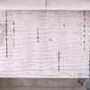 Abstract rug design on wooden floor with cushions.
