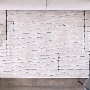 Abstract rug design on wooden floor with cushions.