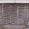 Gray textured rug on wooden floor.