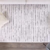 Modern striped rug with cozy pillows in living room.