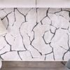 Abstract cracked-pattern rug on wooden floor.