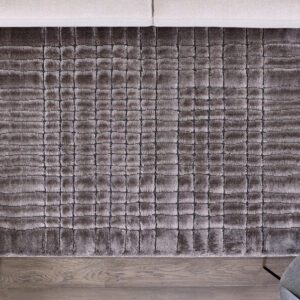 Gray textured rug on wooden floor.