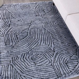 Gray patterned rug on wood floor beside couch.