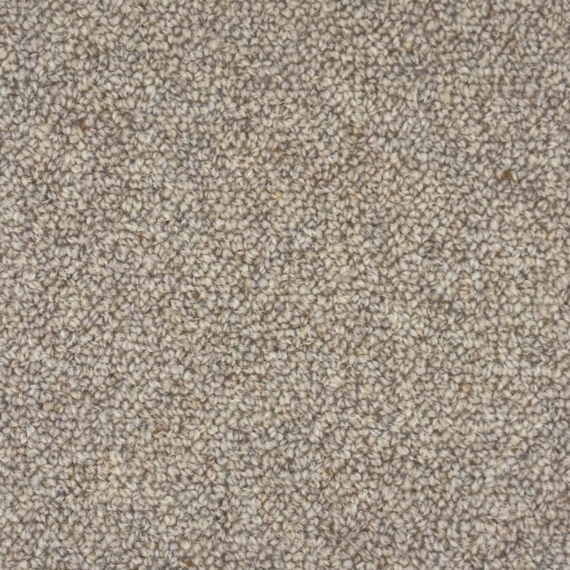 Close-up of beige wool carpet texture.