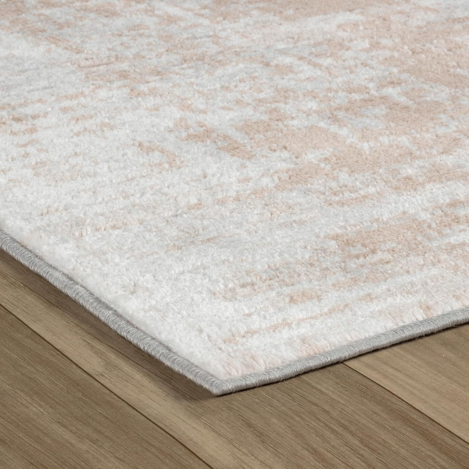 Close-up of beige textured rug on wooden floor