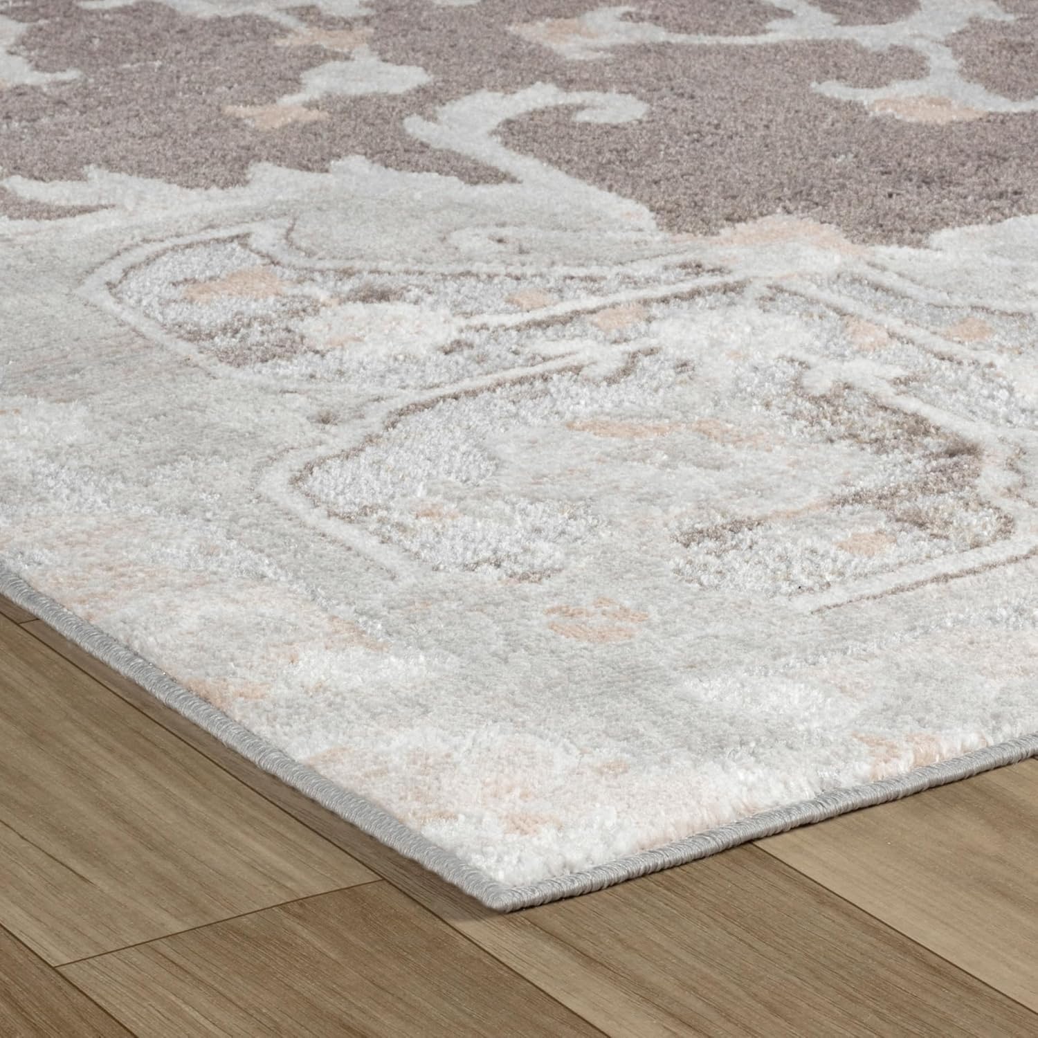 Close-up of patterned area rug on wooden floor.