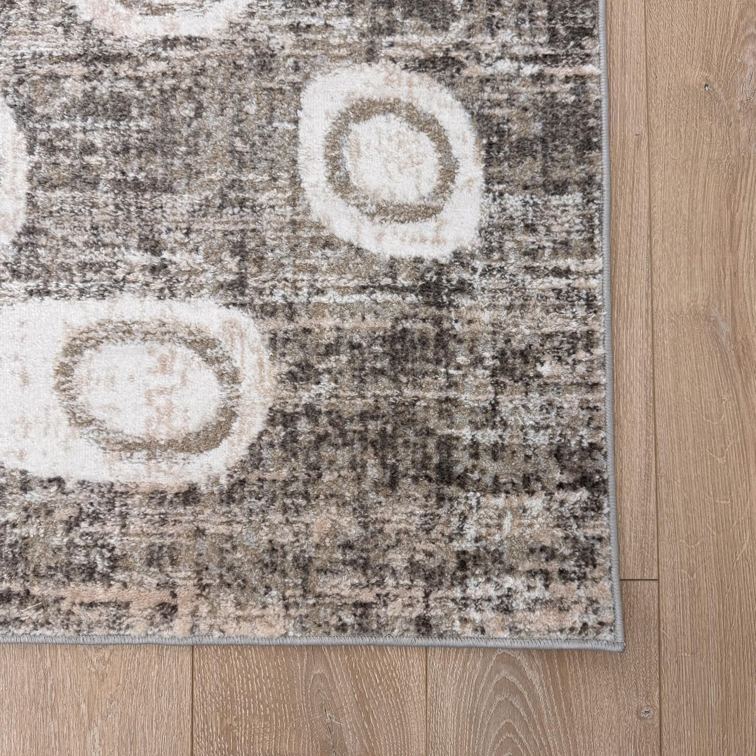 Textured area rug with circular patterns on floor.