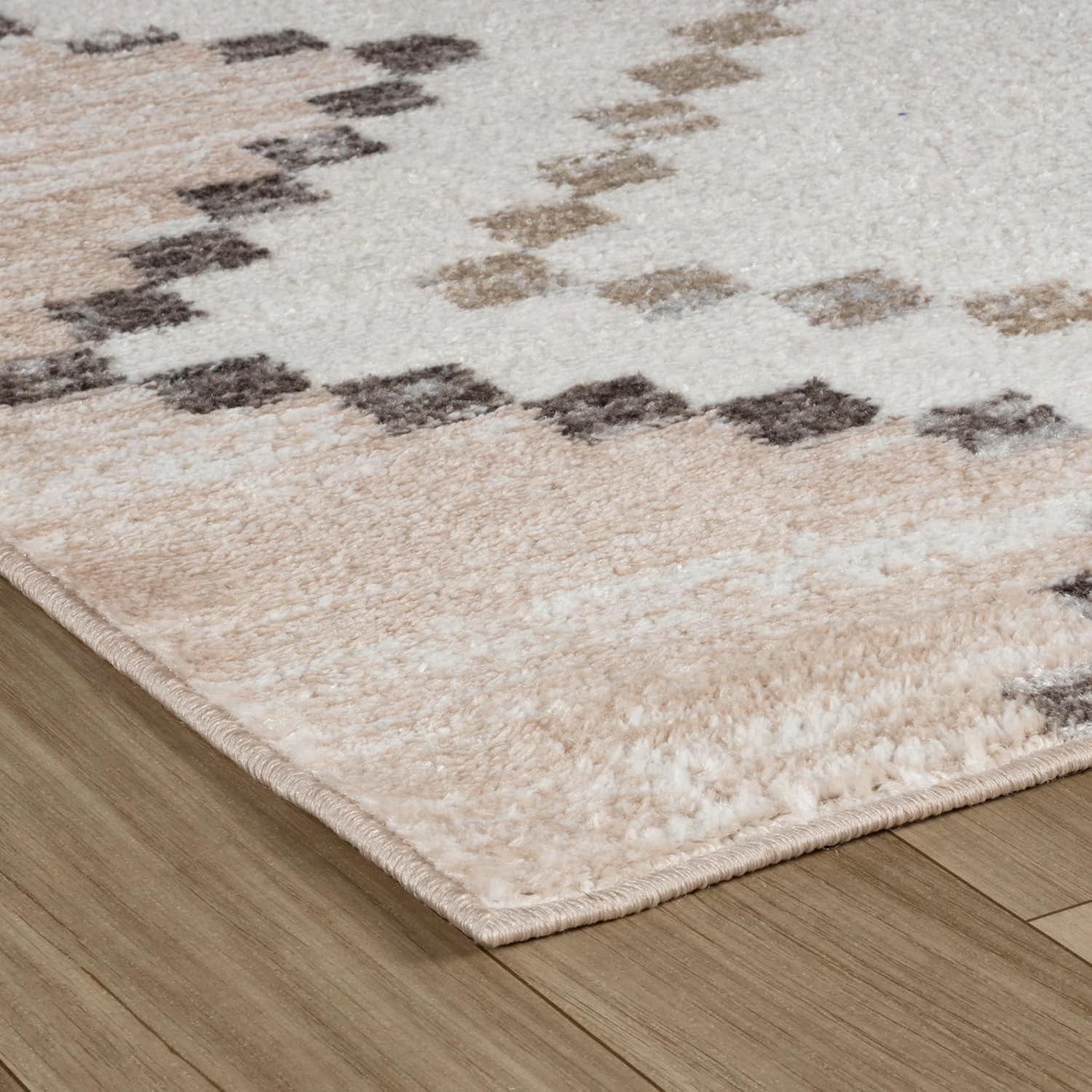 Modern geometric beige area rug on wooden floor.