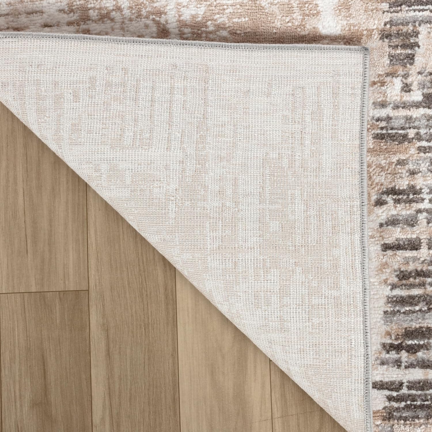 Corner of rug showing underside on wood floor