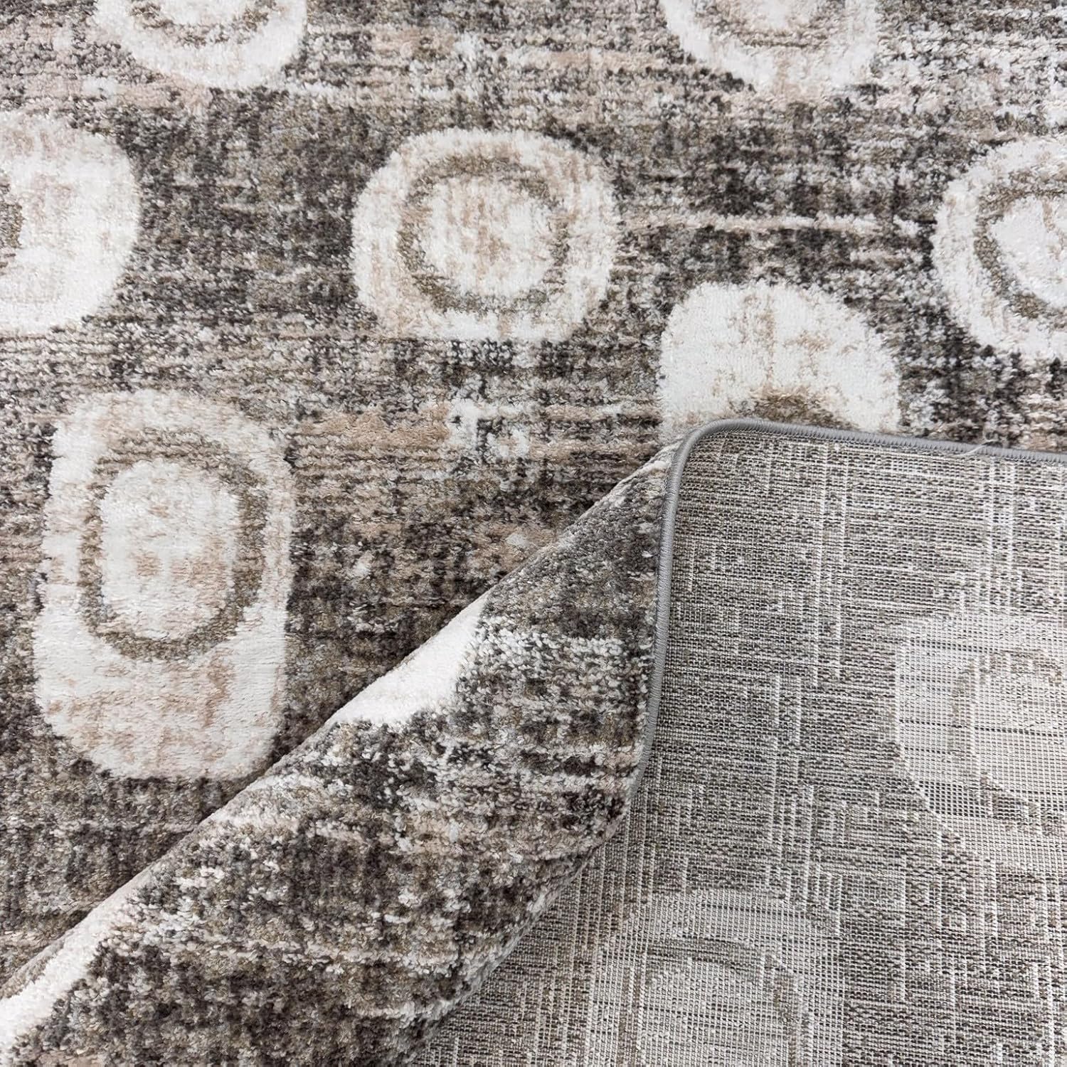Abstract patterned rug with circles and textures.