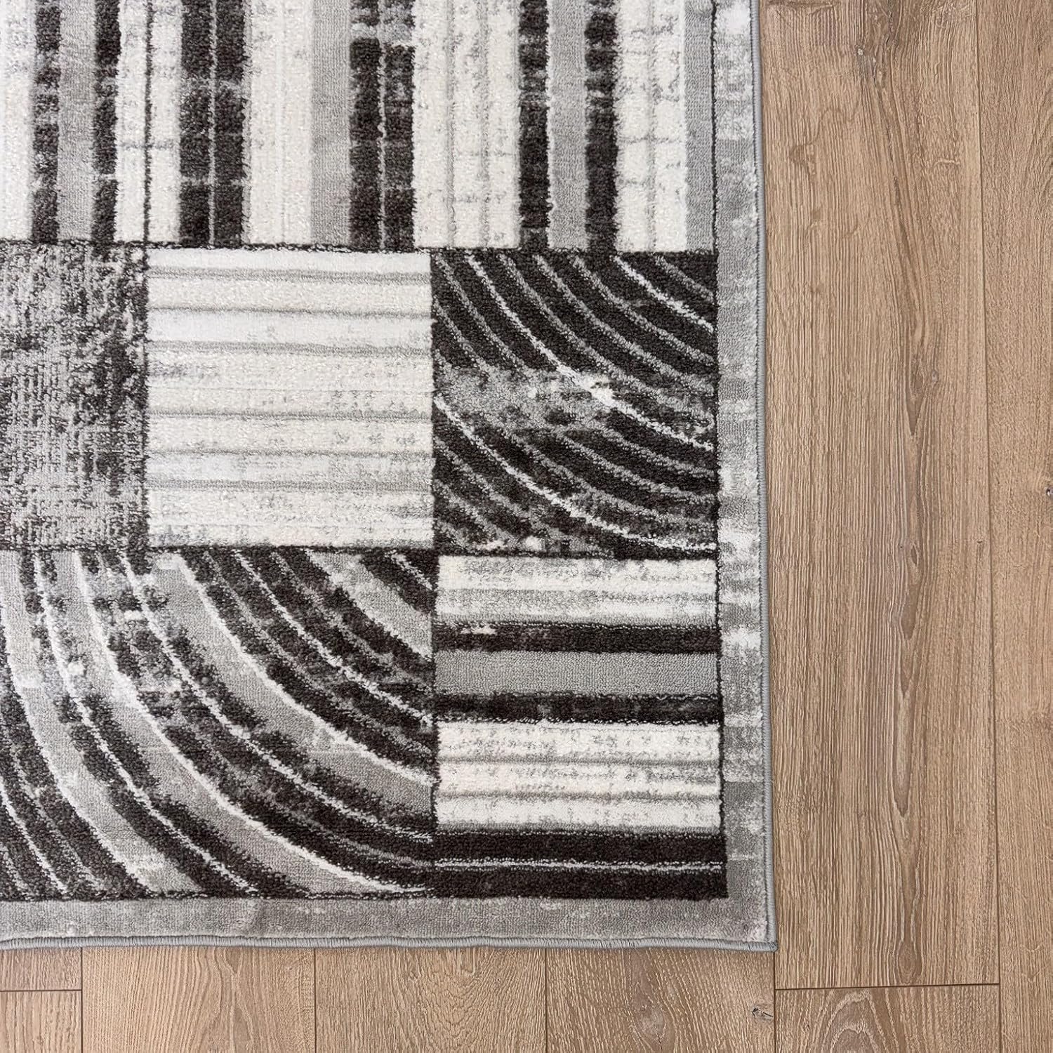 Gray patterned rug on wooden floor.
