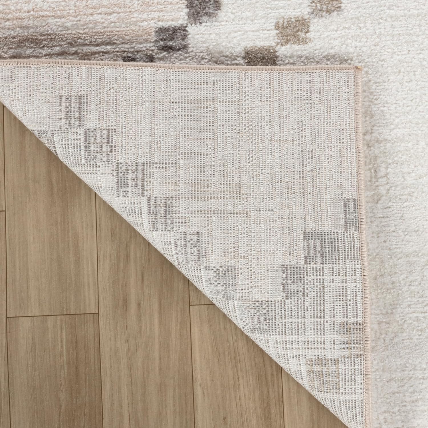 White rug corner flipped on wooden floor